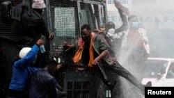 Demonstranti se penju na policijsko vozilo u Najrobiju, 25. jun 2024. (REUTERS/Monicah Mwangi)
