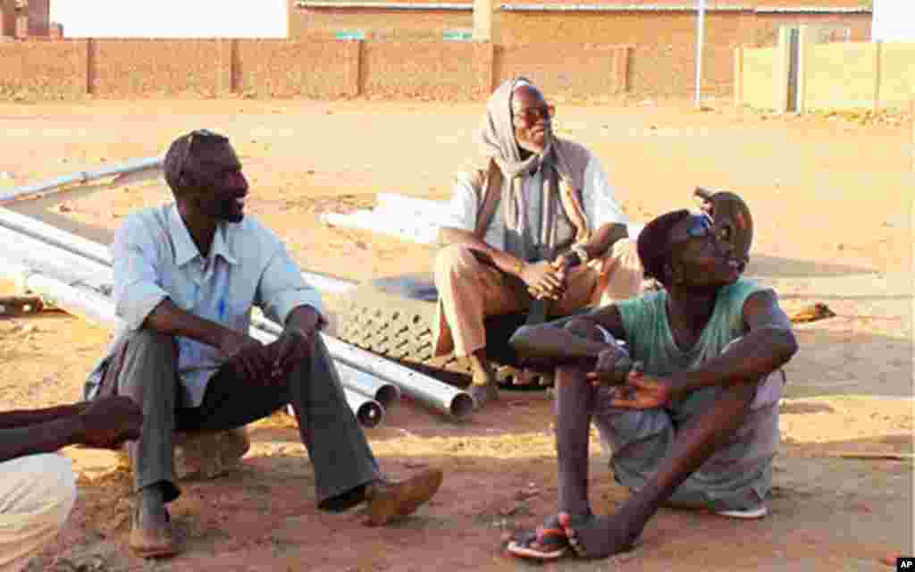 Workers take a break from construction of the new village Murai Janga.