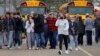 Para orang tua menjauh dari lokasi penembakan bersama anak-anak mereka pasca insiden penembakan di Oxford High School di kota Oxford, Michigan, Selasa (30/11). 