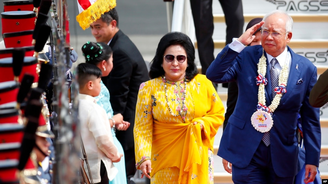 Rosmah Mansor (berbaju kuning) mendampingi suaminya, (saat itu masih menjabat sebagai) Perdana Menteri Malaysia Najib Razak (kanan) di Bandara Internasional Clark di Clark, provinsi Pampanga, Manila Utara, Filipina, 12 November 2017. (Foto: dok).