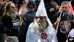 Un membre du Ku Klux Klan escorté par la police lors d'une manifestation à Charlottesville, le 8 juillet 2017.