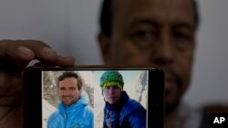 Karrar Haidri, juru bicara Klub Alpine Pakistan, menunjukkan foto dua pendaki gunung yang dinyatakan hilang, Tom Ballard (warga Inggris, kanan) dan Danielle Nardi (Warga Italia, kiri) di Islamabad, Pakistan, 4 Maret 2019.