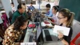 Locals, left, sit for registering their names during a voter registration process of the National Election Committee (NEC) in Phnom Penh, Cambodia, Thursday, Sept. 1, 2016. 