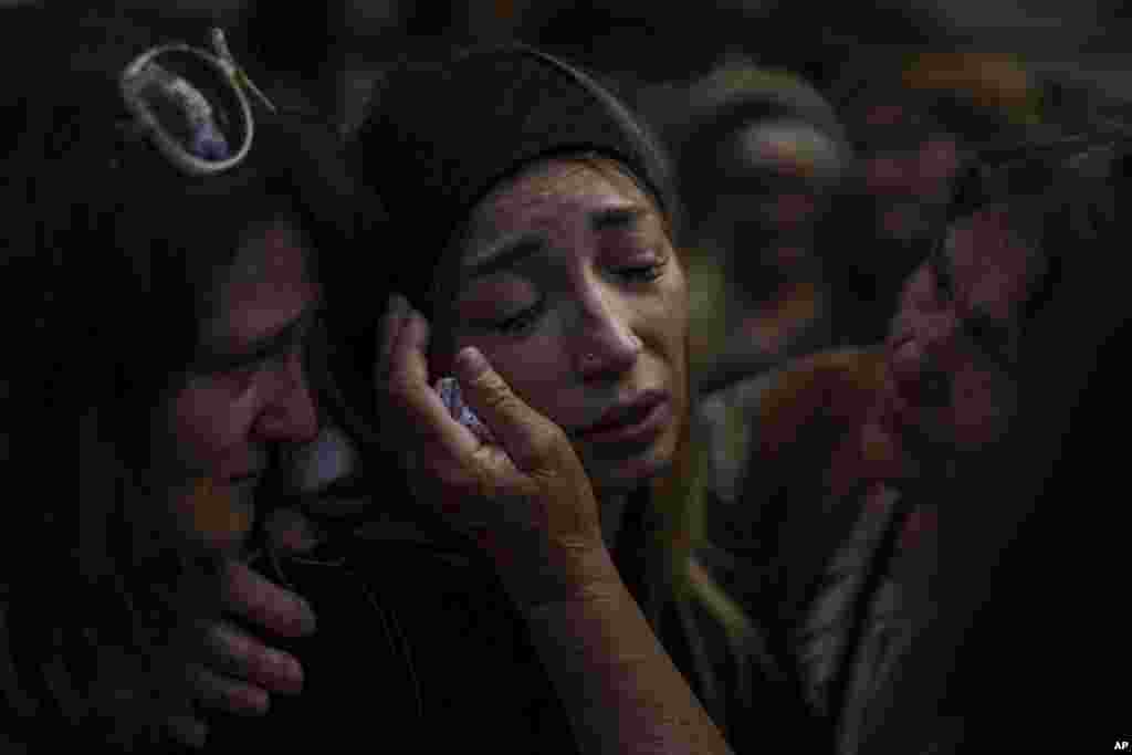 Anastasia Ohrimenko, de 26 años, es consolada por familiares mientras llora junto al féretro de su esposo, Yury Styglyuk, un soldado ucraniano que murió en combate el 24 de agosto, en Maryinka, Donetsk, durante su funeral en Bucha, Ucrania, el 31 de agosto de 2022.