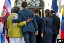 Canadian Prime Minister Justin Trudeau, center, embraces Barbados Prime Minister Mia Mottley at the White House in Washington on Nov. 3, 2023, during the inaugural Americas Partnership for Economic Prosperity Leaders’ Summit.