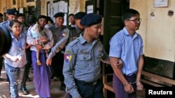 Wartawan Reuters Wa Lone dan Kyaw Soe Oo dikawal oleh polisi untuk kembali ke ruang sidang pengadilan setelah istirahat makan siang di Yangon, Myanmar, 14 Februari 2018. (Foto: dok).