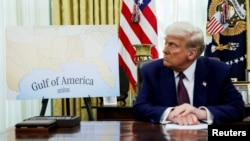 FILE - U.S. President Donald Trump sits next to a map that shows the Gulf of America, in the Oval Office of the White House in Washington, Feb. 13, 2025. 