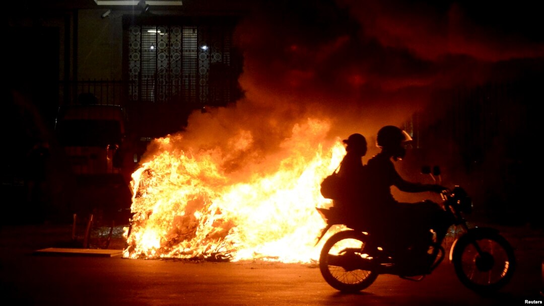 Una motocileta pasa frente a una fogata durante una protesta contra el alza de pasajes en el transporte, en Rio de Janeiro, Brasil.