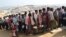 Rohingya refugees stand in a queue to collect aid supplies in Kutupalong refugee camp in Cox's Bazar, Bangladesh, Jan. 21, 2018.