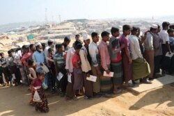FILE - Rohingya refugees stand in a queue to collect aid supplies in Kutupalong refugee camp in Cox's Bazar, Bangladesh, Jan. 21, 2018.