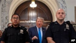 El expresidente Donald Trump habla con periodistas durante un receso en los procedimientos judiciales por una demanda de fraude en su contra en Nueva York, el 2 de octubre de 2023. 