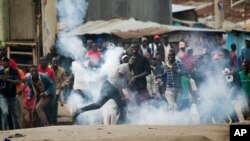 Para pendukung pemimpin oposisi Kenya dan kandidat presiden Raila Odinga melemparkan balik tabung gas air mata pada pasukan keamanan Kenya di daerah kumuh Mathare, Nairobi, Rabu, 9 Agustus 2017 (foto: AP Photo/Jerome Delay)