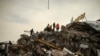 Tim SAR terus melakukan pencarian korban di antara puing-puing bangunan yang runtuh di tengah suhu membeku di Malatya, Turki, Selasa, 7 Februari 2023. (AP/Emrah Gurel)