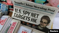 A copy of the South China Morning Post newspaper, carrying the latest interview with Edward Snowden, is displayed on a newspaper stand along with local Chinese newspapers, in Hong Kong, June 13, 2013.