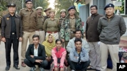 Members of a Muslim Rohingya family sit as they pose for a photograph with Indian and Myanmar security officials before their deportation on India-Myanmar border at Moreh in the northeastern state of Manipur, India, Jan. 3, 2019. 