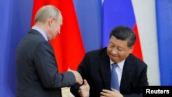 Владимир Путин и Си Цзиньпинь приветствуют друг друга