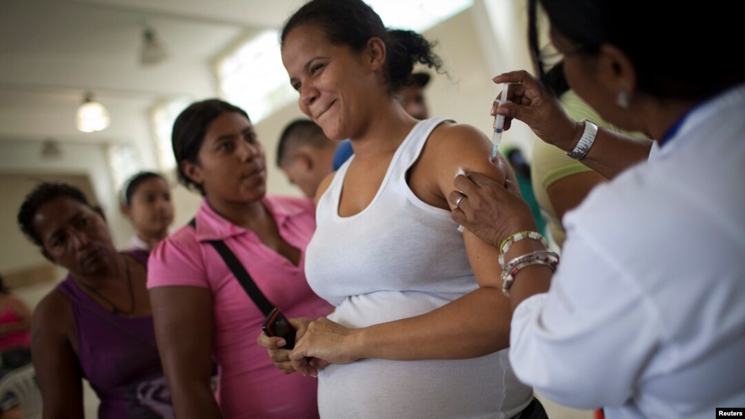 Reaksi seorang ibu hamil saat divaksinasi di sebuah rumah singgah di markas besar Kepolisian Nasional Bolivarian, di daerah kumuh Catia, di Caracas, 29 November 2010.