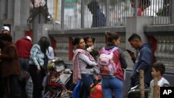 Los migrantes venezolanos esperan en la embajada de su país un autobús que los transportará al aeropuerto de Lima, Perú. Foto de archivo.