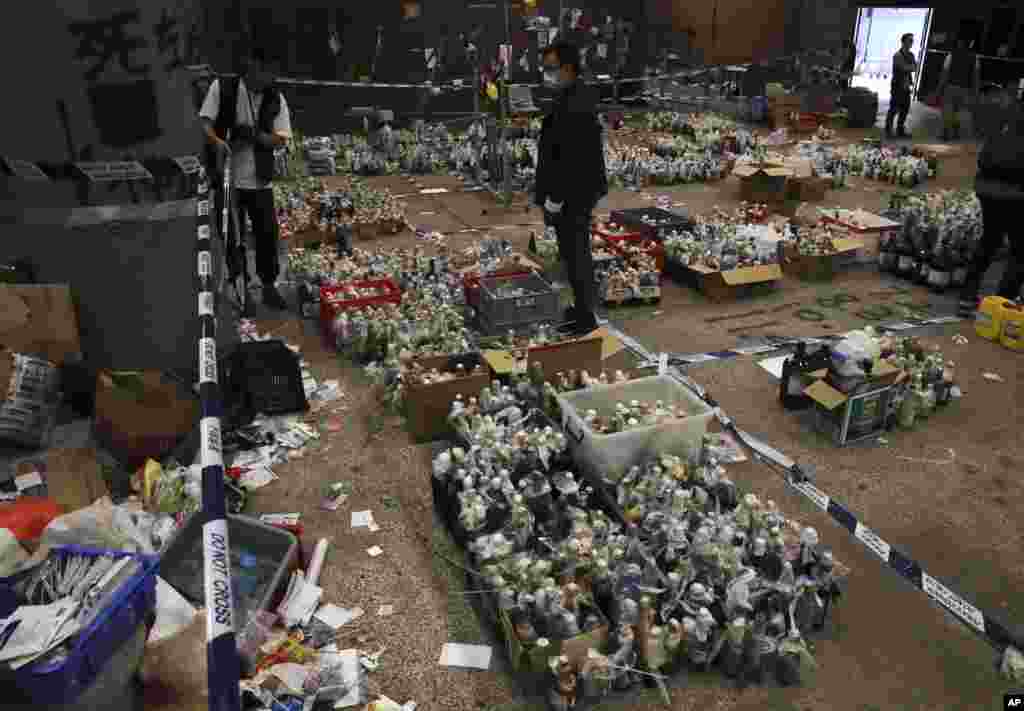 Police collect gas canisters and flammable material as evidence in a cordoned off area in the Polytechnic University campus in Hong Kong.