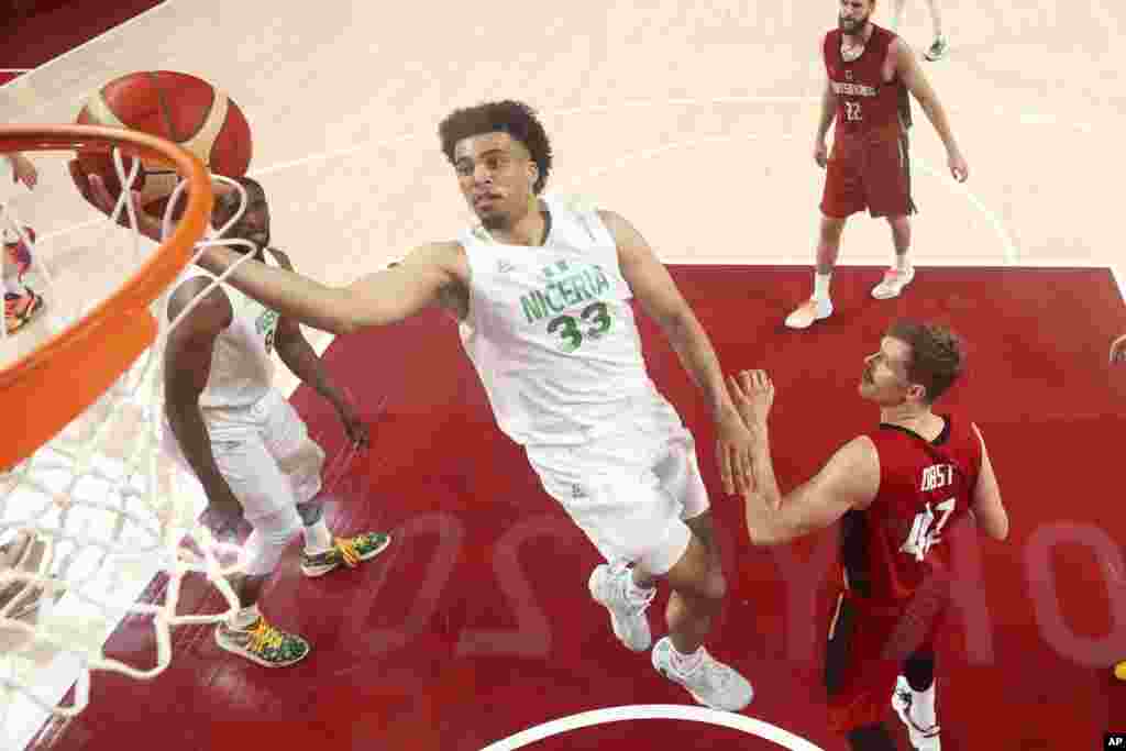 Nigeria's Jordan Nwora (33) drives to the basket over Germany's Andreas Obst (42) during a men's basketball preliminary round game at the 2020 Summer Olympics, Wednesday, July 28, 2021, in Saitama, Japan. (Gregory Shamus/Pool Photo via AP)