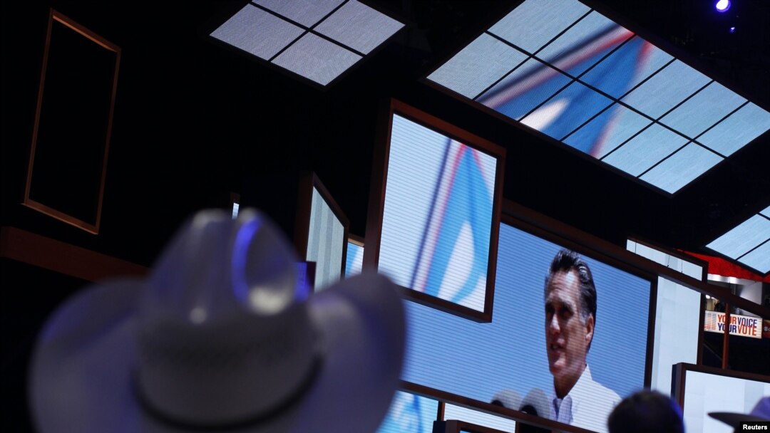 Para delegasi melihat gambar capres AS Mitt Romney pada upacara pembukaan konvensi nasional partai Republik di Tampa, Florida, Senin (27/8). Romney dijadwalkan tiba di Tampa hari Selasa ini. 