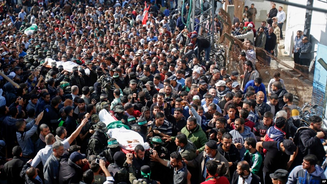 Palestinian mourners carry the bodies of two of the seven Hamas militants who were killed in an Israeli raid late Sunday, during their funerals in Khan Younis, southern Gaza Strip, Nov. 12, 2018.