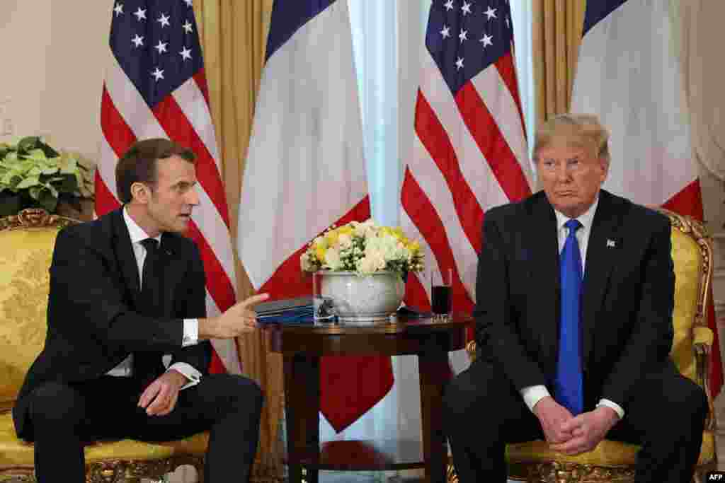 U.S. President Donald Trump (R) listens as French President Emmanuel Macron speaks during their meeting at Winfield House, London.