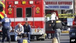 Emergency personnel work at the scene where Rep. Gabrielle Giffords, D-Ariz., and others were shot outside a Safeway grocery store in Tucson, Ariz. on Saturday, Jan. 8, 2011.