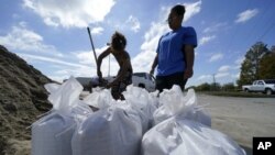 Warga AS di kota Houma, Louisiana bersiap melindungi rumah mereka dengan kantong-kantong pasir menjelang datangnya badai Delta yang diperkiarakan tiba di Louisiana Jumat (9/10) malam.