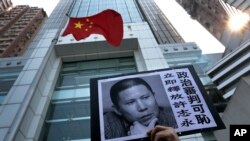 A placard with a photo of legal scholar Xu Zhiyong is raised by a demonstrator protesting against a Chinese court’s decision to sentence him in prison outside the Chinese liaison office in Hong Kong, Jan. 27, 2014.