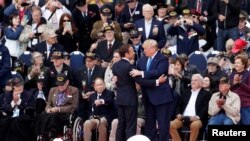 El presidente Donald Trump y el presidente francés, Emmanuel Macron, durante una ceremonia para conmemorar el 75 aniversario del Día D en el cementerio y monumento estadounidense de Normandía, Francia, el 6 de junio de 2019.