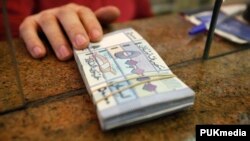 A money exchange vendor displays Lebanese pound banknotes at his shop in Beirut, Feb. 7, 2012. 