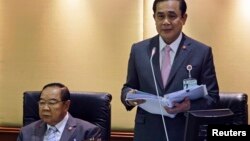 Perdana Menteri Thailand Prayuth Chan-ocha (kanan) membacakan kebijakan pemerintah, didampingi Wakil Perdana Menteri dan Menteri Pertahanan Prawit Wongsuwan di Parlemen di Bangkok, September 2014.