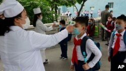 Anak-anak SD di Pyongyang, Korea Utara diperiksa suhu tubuhnya sebelum masuk ke kelas mereka (foto: dok). 