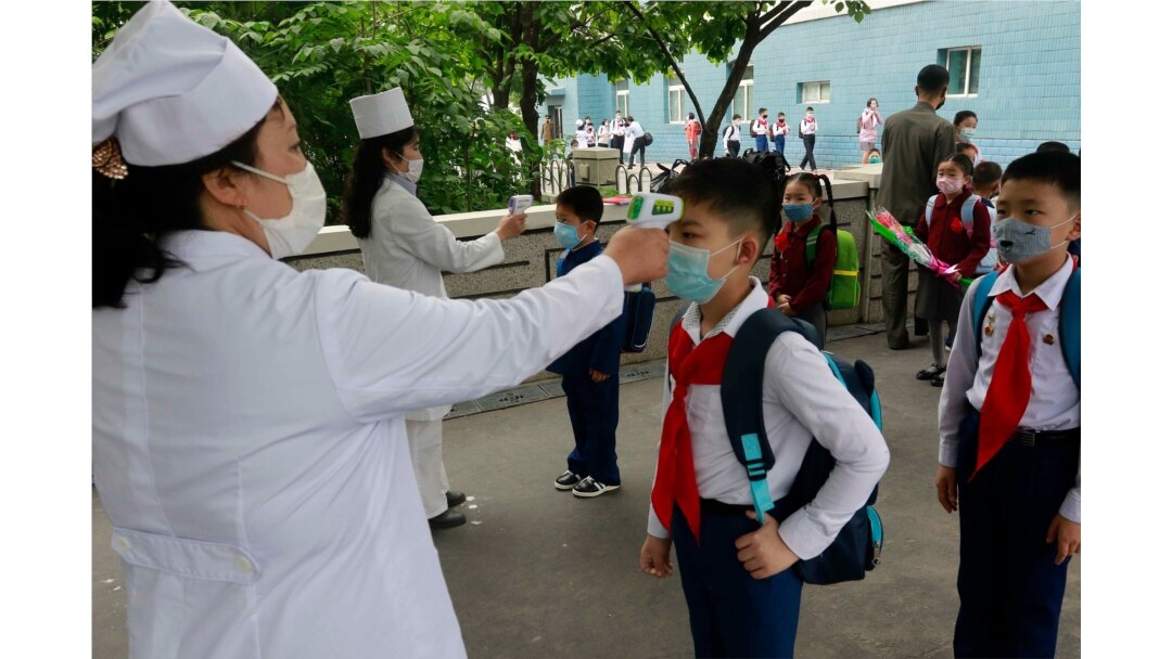 FILE - Kim Song Ju Primary School students have their temperatures checked in Pyongyang, North Korea, June 3, 2020. After months of denying it had any coronavirus infections, North Korea reported its first suspected case July 25, 2020.