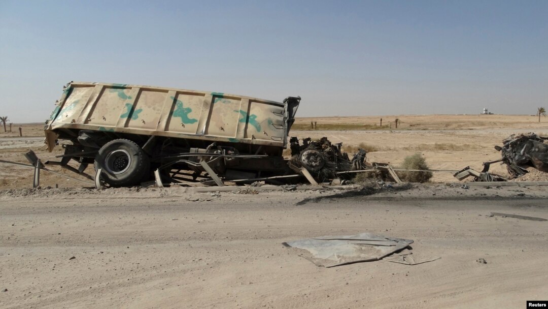 FILE - A burnt vehicle belonging to the Iraqi security forces is seen on the outskirt of Haditha, northwest of Baghdad August 26, 2014. On Monday, Jan. 4, 2016, IS militants attacked Iraqi troops and allied tribal fighters outside Haditha, killing at least 11 and wounding dozens.