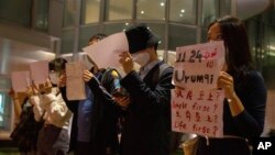 Protesters hold up white paper some with writings commemorating the Nov 24 deadly Urumqi fire during a gathering at the University of Hong Kong in Hong Kong, Tuesday, Nov. 29, 2022. (AP Photo/Bertha Wang)