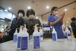 Umat Kristiani yang memakai masker wajah menggunakan hand sanitizer sebelum menghadiri kebaktian di Gereja Injil Penuh Yoido di Seoul, Korea Selatan, Minggu, 5 Juli 2020. (Foto: AP/Ahn Young-joon)