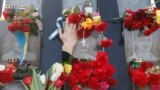 A demonstrator places flowers at the monument of the so-called &quot;Nebesna Sotnya&quot; (Heavenly Hundred), the anti-government protesters killed during the Ukrainian pro-European Union (EU) mass protests in 2014, during a rally commemorating the third anniversary of protests, in central Kyiv.