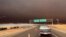 Smoke from the Camp Fire, burning in the Feather River Canyon near Paradise, Calif., darkens the sky as seen from Highway 99 near Marysville, Calif., Nov. 8, 2018. 
