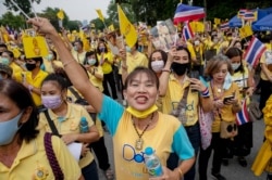 Supporters of the Thai monarchy wave national flags and sing during a rally at Lumphini park in central Bangkok, Thailand, Oct. 27, 2020.