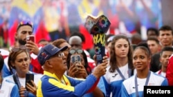 Former Venezuela baseball player Angel Alfonso Bravo Urdaneta is seen with the flame during the opening ceremony for the Alba Games in Macuto, Venezuela, April 21, 2023.