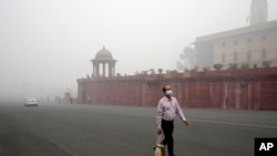 A man walks wearing a face mask amidst a thick layer of smog as air pollution shoots up in New Delhi, Nov. 18, 2024. Residents woke up to thick, toxic smog enveloping the city of some 33 million as the air quality became increasingly hazardous.