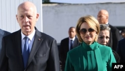 Tunisia's President Kais Saied arrives with his wife, magistrate Ichraf Chebil, to cast their votes at a polling station in Tunis during the country's presidential election on Oct. 6, 2024.