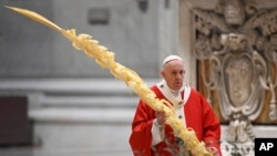 Pope Francis holds a palm branch as he celebrates Palm Sunday Mass behind closed doors in St. Peter's Basilica, at the Vatican, April 5, 2020, during the lockdown aimed at curbing the spread of the COVID-19 infection, caused by the novel coronavirus.