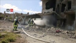 FILE - Firefighters respond at the destroyed building of Nabd Al-Hayat hospital that was hit by an airstrike in Hass, Idlib province, Syria, May 6, 2019, in this still image taken from a video on May 9, 2019.