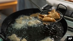 FILE - Pestiños, honey-coated pastries, are cooked by the cloistered nuns of the Clarisas convent in Carmona, Spain, on November 30, 2023.