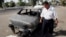 FILE - An Iraqi traffic policeman inspecting a car destroyed by a Blackwater security detail in al-Nisoor Square in Baghdad, Iraq, Sept. 25, 2007. 