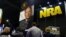 FILE - People sign up at the booth for the National Rifle Association at the Conservative Political Action Conference at National Harbor, Maryland, Feb. 23, 2018.