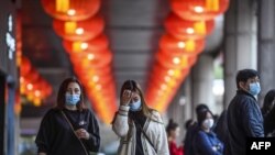 Pedestrians wear face masks as they walk outside the New Orient Landmark hotel in Macau.